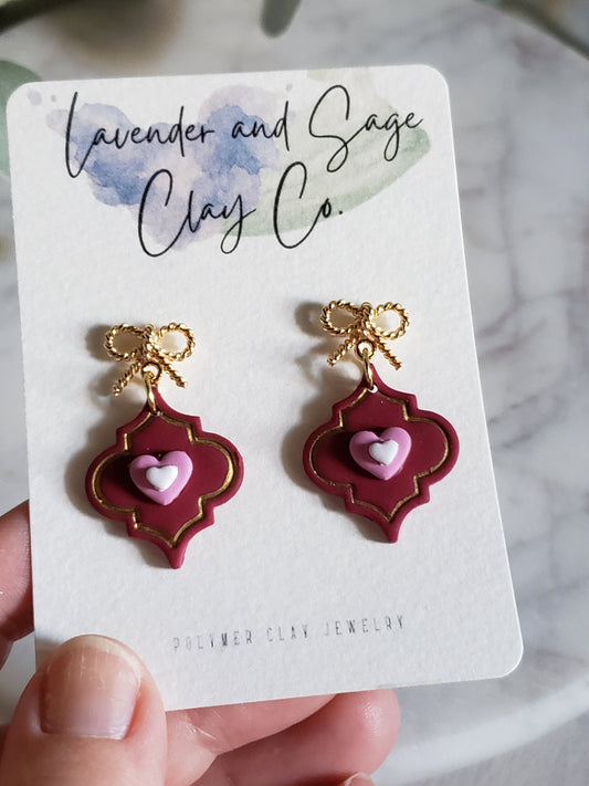 Clay Valentines earrings Berry color Moroccan frame with gold bow and hearts .